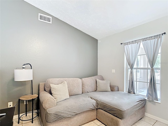 living room with plenty of natural light, light tile patterned floors, lofted ceiling, and baseboards