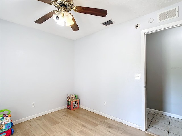 empty room featuring light wood-style floors, ceiling fan, and baseboards