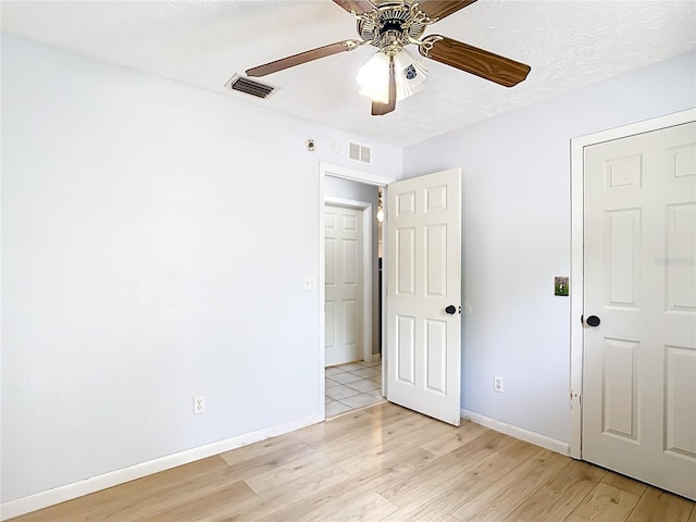 unfurnished bedroom featuring light wood finished floors, baseboards, and a ceiling fan
