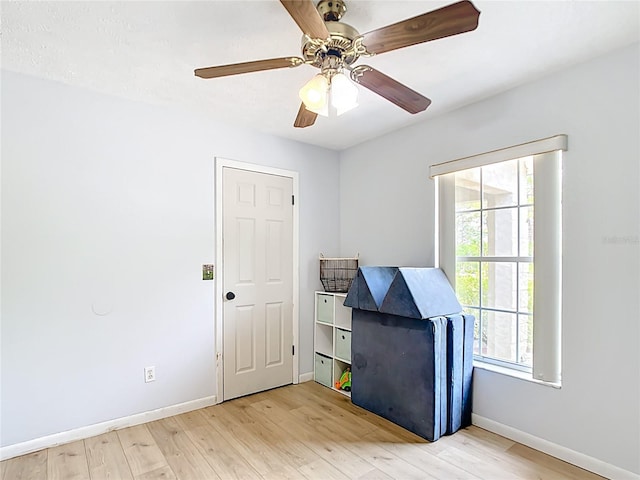 empty room with light wood finished floors, baseboards, and ceiling fan