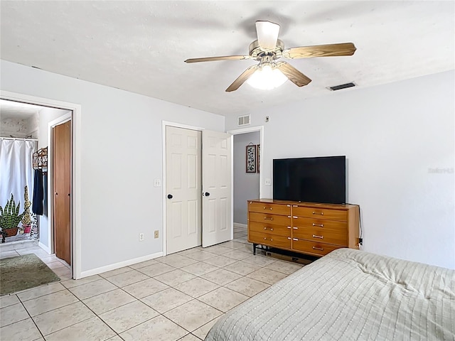 bedroom featuring light tile patterned flooring, baseboards, and a ceiling fan