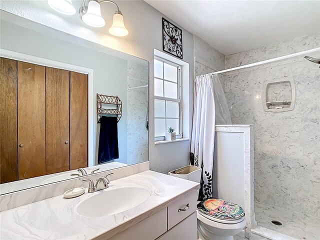 full bath featuring a shower stall, vanity, and toilet