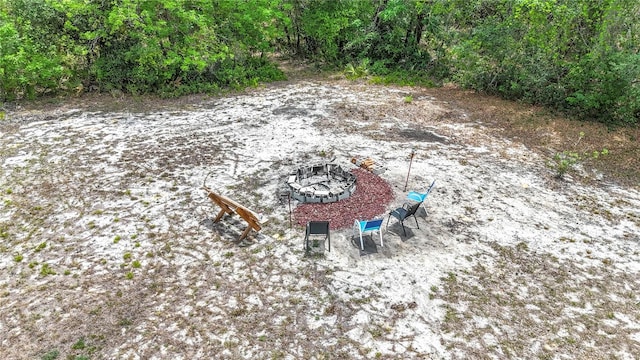 view of yard with an outdoor fire pit and a view of trees