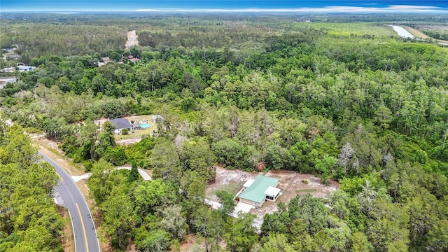 aerial view of property and surrounding area featuring a heavily wooded area