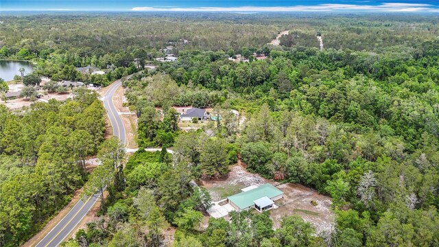 aerial view of property's location featuring a forest