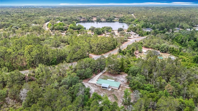 aerial view of property and surrounding area with a forest and a large body of water
