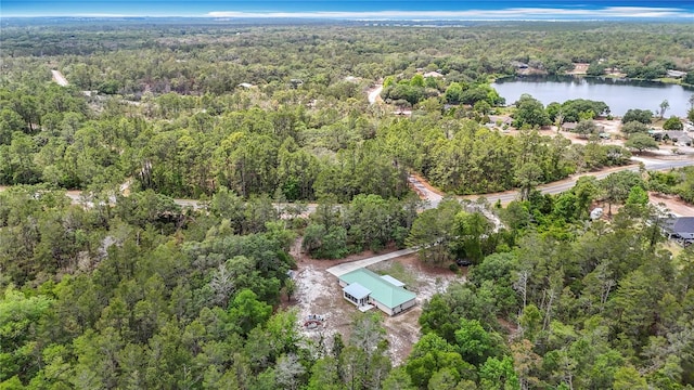 view of property location with a heavily wooded area and a nearby body of water