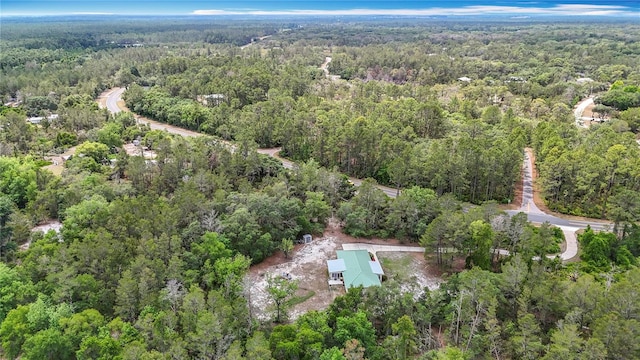 aerial view of property and surrounding area with a heavily wooded area