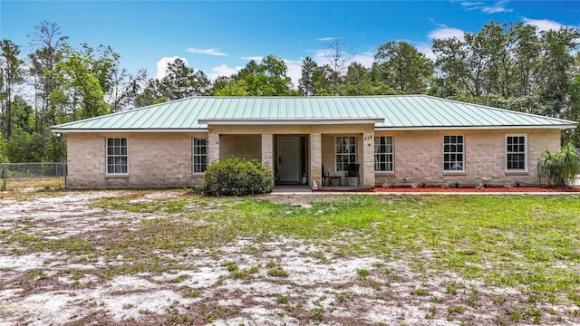 back of property featuring stone siding, a porch, and metal roof
