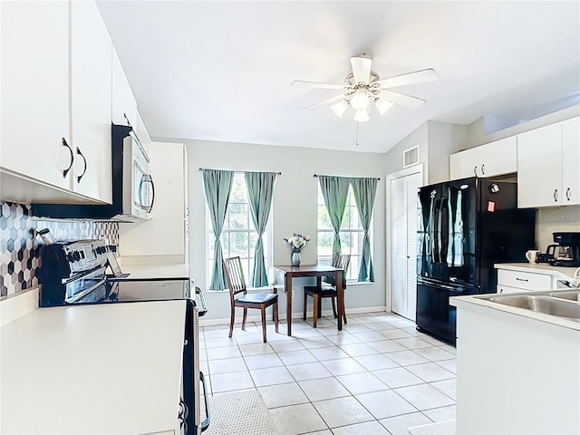 kitchen with freestanding refrigerator, ceiling fan, white cabinetry, vaulted ceiling, and light tile patterned floors