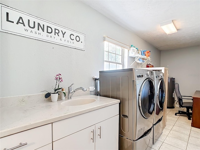 laundry room featuring washing machine and clothes dryer, cabinet space, and light tile patterned flooring
