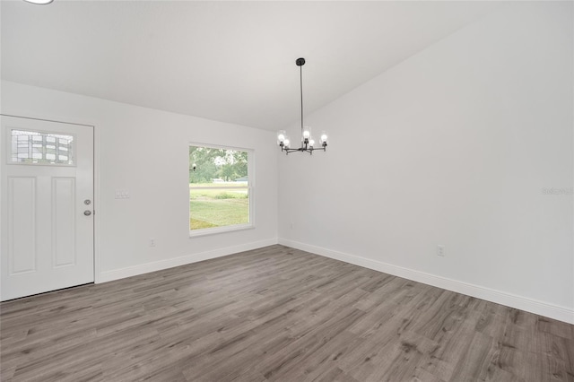 9731 Bahia Rd, Ocala, FL 34472 - entryway with lofted ceiling, a chandelier, wood finished floors, and baseboards