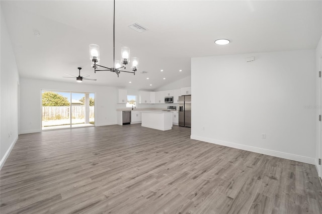 9731 Bahia Rd, Ocala, FL 34472 - unfurnished living room with a chandelier, vaulted ceiling, light wood-style flooring, baseboards, and recessed lighting
