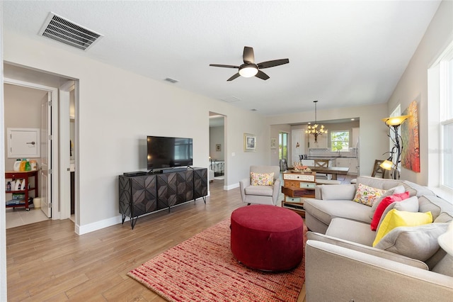 8820 SW 58th Street Rd, Ocala, FL 34481 - living area featuring a chandelier, light wood-type flooring, a ceiling fan, and baseboards