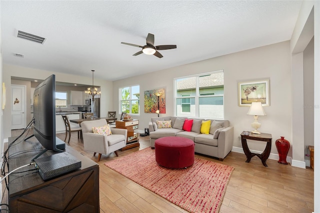 8820 SW 58th Street Rd, Ocala, FL 34481 - living room featuring a chandelier, a ceiling fan, light wood-type flooring, and baseboards