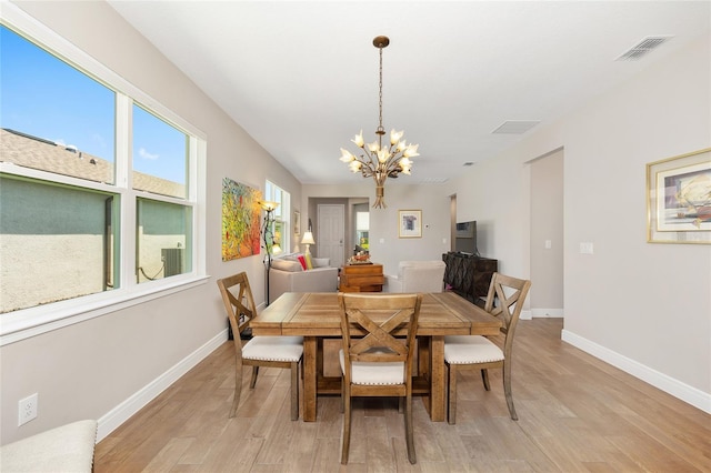 8820 SW 58th Street Rd, Ocala, FL 34481 - dining space featuring a chandelier, light wood finished floors, and baseboards