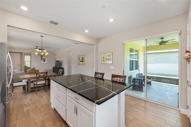 8820 SW 58th Street Rd, Ocala, FL 34481 - kitchen with freestanding refrigerator, light wood-style flooring, dark countertops, white cabinetry, and recessed lighting