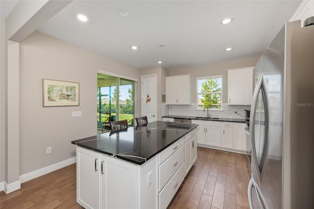 8820 SW 58th Street Rd, Ocala, FL 34481 - kitchen featuring freestanding refrigerator, light wood-style flooring, a sink, dark countertops, and a kitchen island