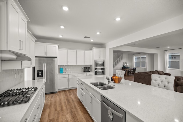 7199 SW 60th Ln, Ocala, FL 34474 - kitchen with stainless steel appliances, a sink, under cabinet range hood, open floor plan, and white cabinets