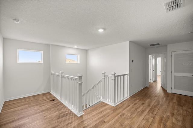 7199 SW 60th Ln, Ocala, FL 34474 - hall with an upstairs landing, wood finished floors, a textured ceiling, baseboards, and recessed lighting