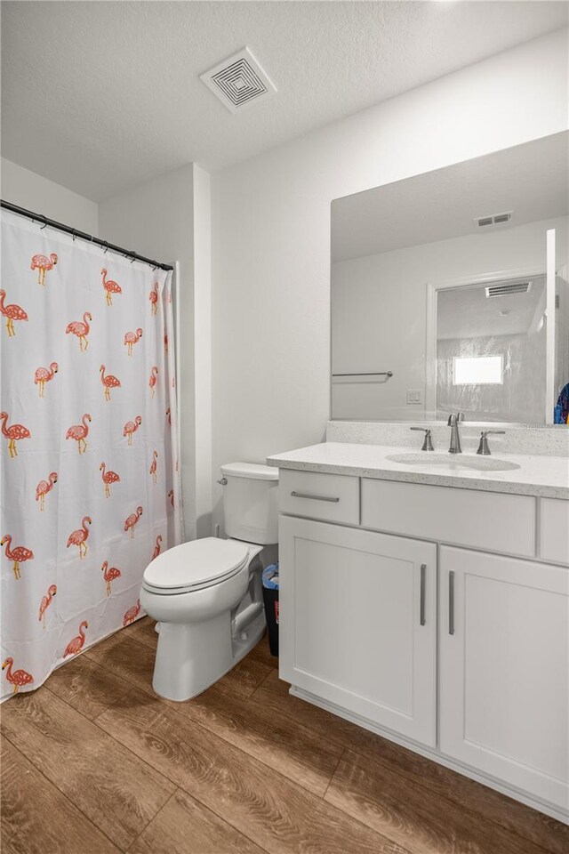 7199 SW 60th Ln, Ocala, FL 34474 - bathroom featuring wood finished floors, toilet, vanity, a textured ceiling, and a shower with curtain