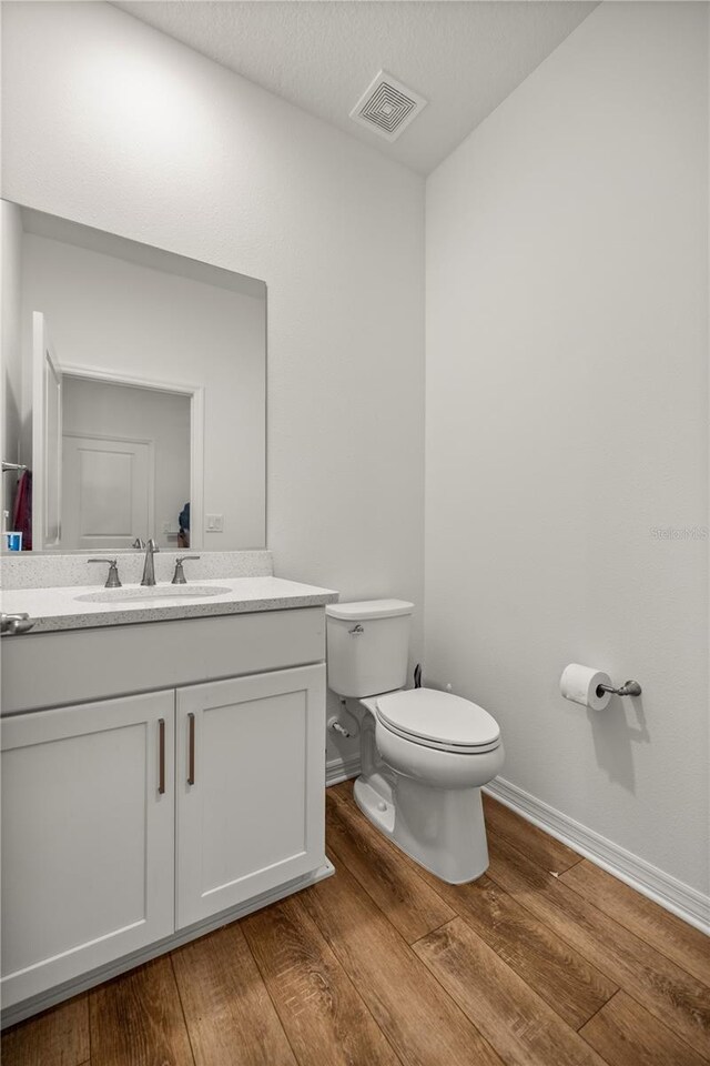 7199 SW 60th Ln, Ocala, FL 34474 - bathroom featuring toilet, wood finished floors, vanity, and baseboards