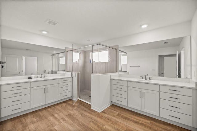 7199 SW 60th Ln, Ocala, FL 34474 - bathroom featuring a stall shower, two vanities, wood finished floors, and recessed lighting