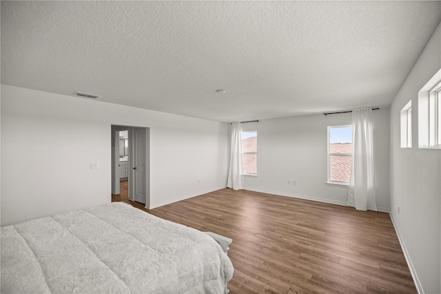 7199 SW 60th Ln, Ocala, FL 34474 - bedroom featuring a textured ceiling, wood finished floors, and baseboards
