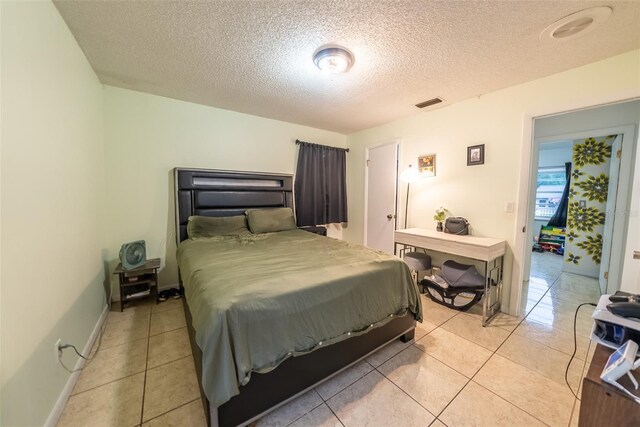2140 NE 40th St, Ocala, FL 34479 - bedroom with a textured ceiling, light tile patterned floors, and baseboards
