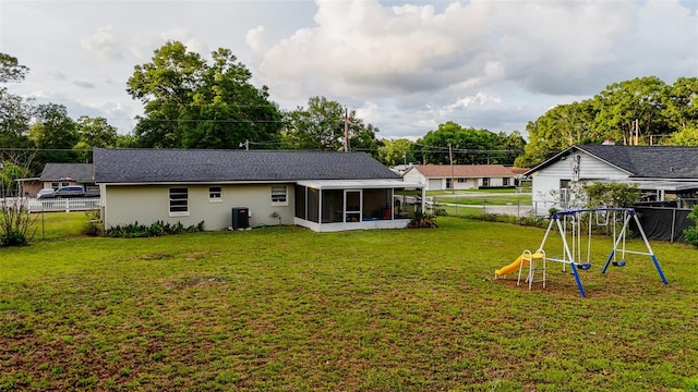 2140 NE 40th St, Ocala, FL 34479 - back of property featuring a sunroom, a playground, central AC unit, and stucco siding