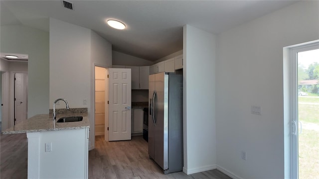 5323 NW 8th Pl, Ocala, FL 34482 - kitchen with stainless steel refrigerator with ice dispenser, a sink, lofted ceiling, a peninsula, and light wood-style flooring