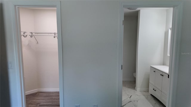 5323 NW 8th Pl, Ocala, FL 34482 - bathroom with baseboards, toilet, a walk in closet, marble finish flooring, and vanity