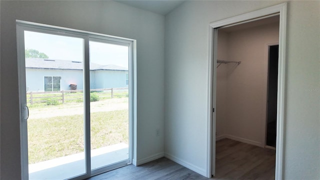 5323 NW 8th Pl, Ocala, FL 34482 - unfurnished bedroom with wood finished floors, a walk in closet, baseboards, access to exterior, and a closet