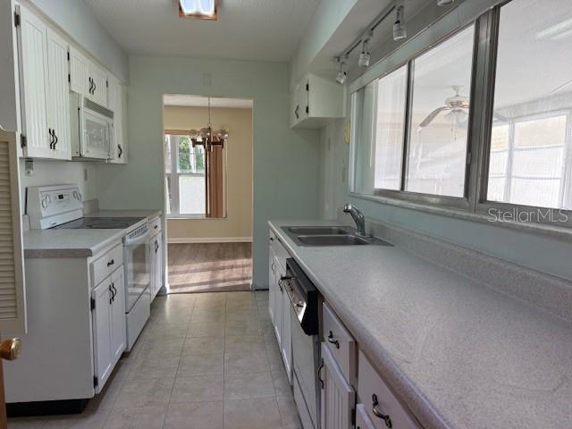 616 Water Rd, Ocala, FL 34472 - kitchen featuring white appliances, a sink, a chandelier, light countertops, and white cabinets