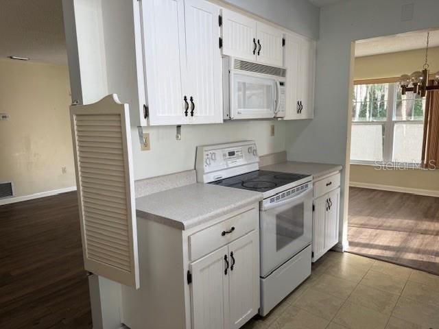 616 Water Rd, Ocala, FL 34472 - kitchen featuring white appliances, light countertops, white cabinetry, and a chandelier