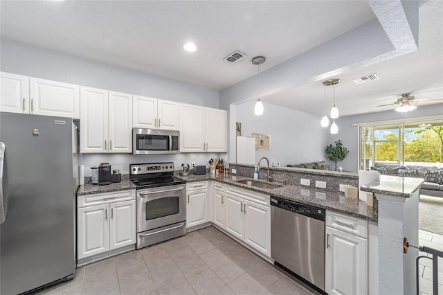 4927 SW 45th Cir, Ocala, FL 34474 - kitchen featuring appliances with stainless steel finishes, a sink, a peninsula, open floor plan, and white cabinetry