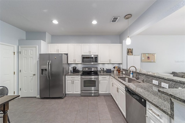 4927 SW 45th Cir, Ocala, FL 34474 - kitchen featuring appliances with stainless steel finishes, a sink, white cabinets, dark stone counters, and recessed lighting