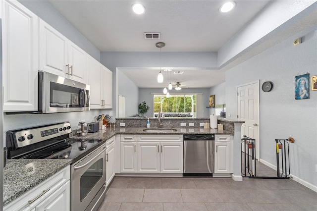 4927 SW 45th Cir, Ocala, FL 34474 - kitchen with stainless steel appliances, a peninsula, light tile patterned floors, white cabinetry, and recessed lighting