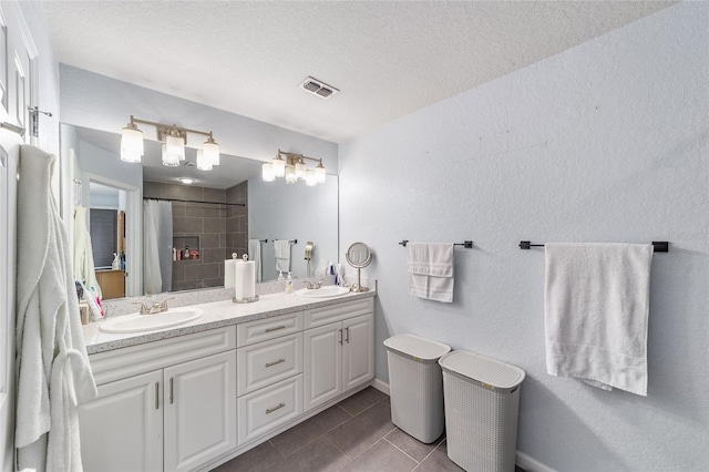 4927 SW 45th Cir, Ocala, FL 34474 - full bathroom with tile patterned floors, tiled shower, double vanity, a textured ceiling, and baseboards