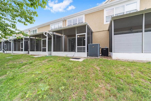 4927 SW 45th Cir, Ocala, FL 34474 - rear view of house featuring a sunroom, central air condition unit, a lawn, and stucco siding