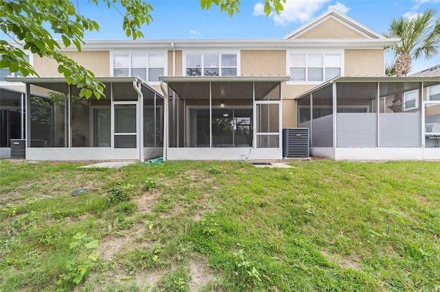 4927 SW 45th Cir, Ocala, FL 34474 - rear view of house featuring a sunroom, stucco siding, a lawn, and central AC