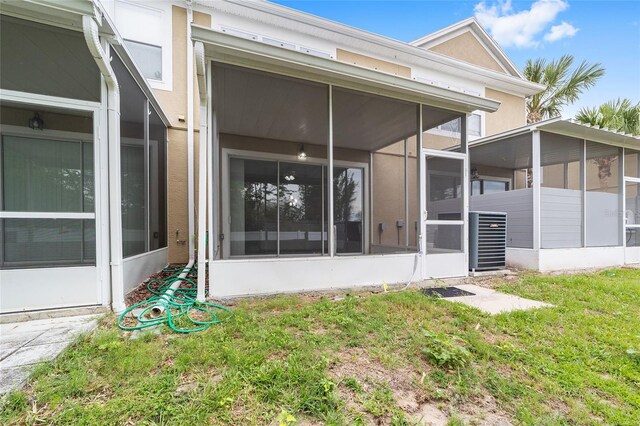4927 SW 45th Cir, Ocala, FL 34474 - back of property with a sunroom, a lawn, central AC, and stucco siding