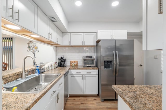 3815 NE 17th Street Cir, Ocala, FL 34470 - kitchen with stainless steel appliances, a sink, white cabinetry, light wood-type flooring, and recessed lighting
