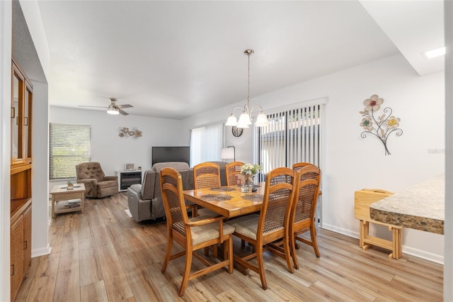 3815 NE 17th Street Cir, Ocala, FL 34470 - dining area featuring light wood-style flooring, a chandelier, a ceiling fan, and baseboards