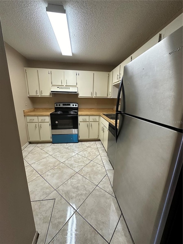 kitchen with appliances with stainless steel finishes, extractor fan, a textured ceiling, and light tile patterned flooring