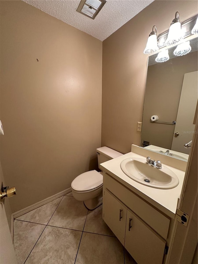half bath featuring a textured ceiling, toilet, tile patterned floors, and vanity