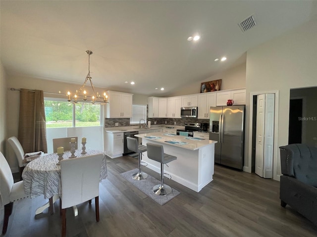 kitchen featuring stainless steel appliances, decorative backsplash, white cabinets, dark wood-style floors, and light countertops