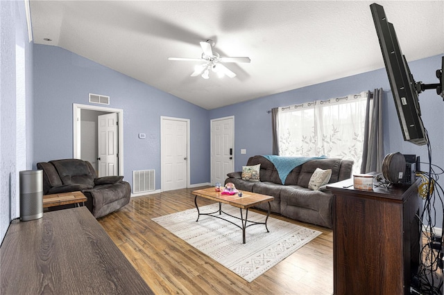 living room featuring lofted ceiling, ceiling fan, wood finished floors, and baseboards