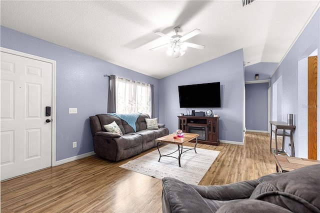 living area featuring vaulted ceiling, wood finished floors, ceiling fan, and baseboards