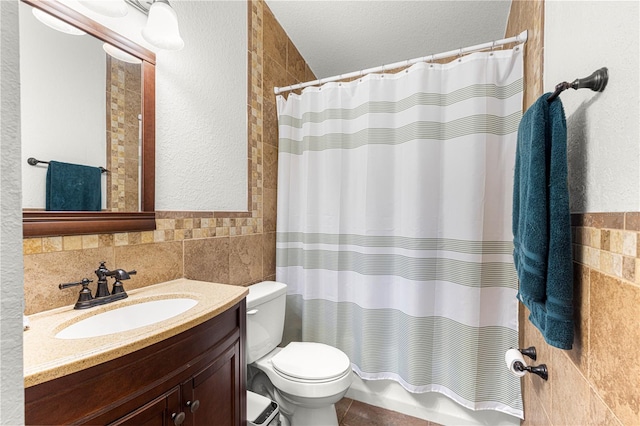 full bathroom with tile walls, toilet, vanity, and shower / bath combination with curtain
